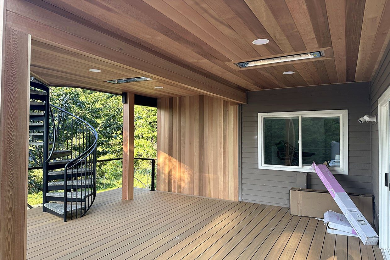A covered deck space featuring a finished wood tongue-and-groove ceiling, recessed lights, heaters, and a spiral staircase.