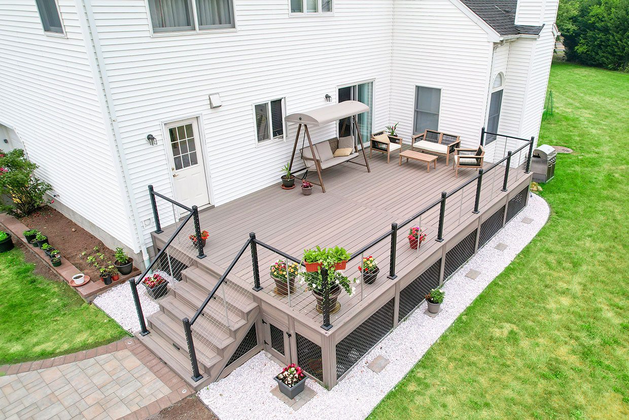 High-angle view of a grey composite deck with black railings and lattice skirting.
