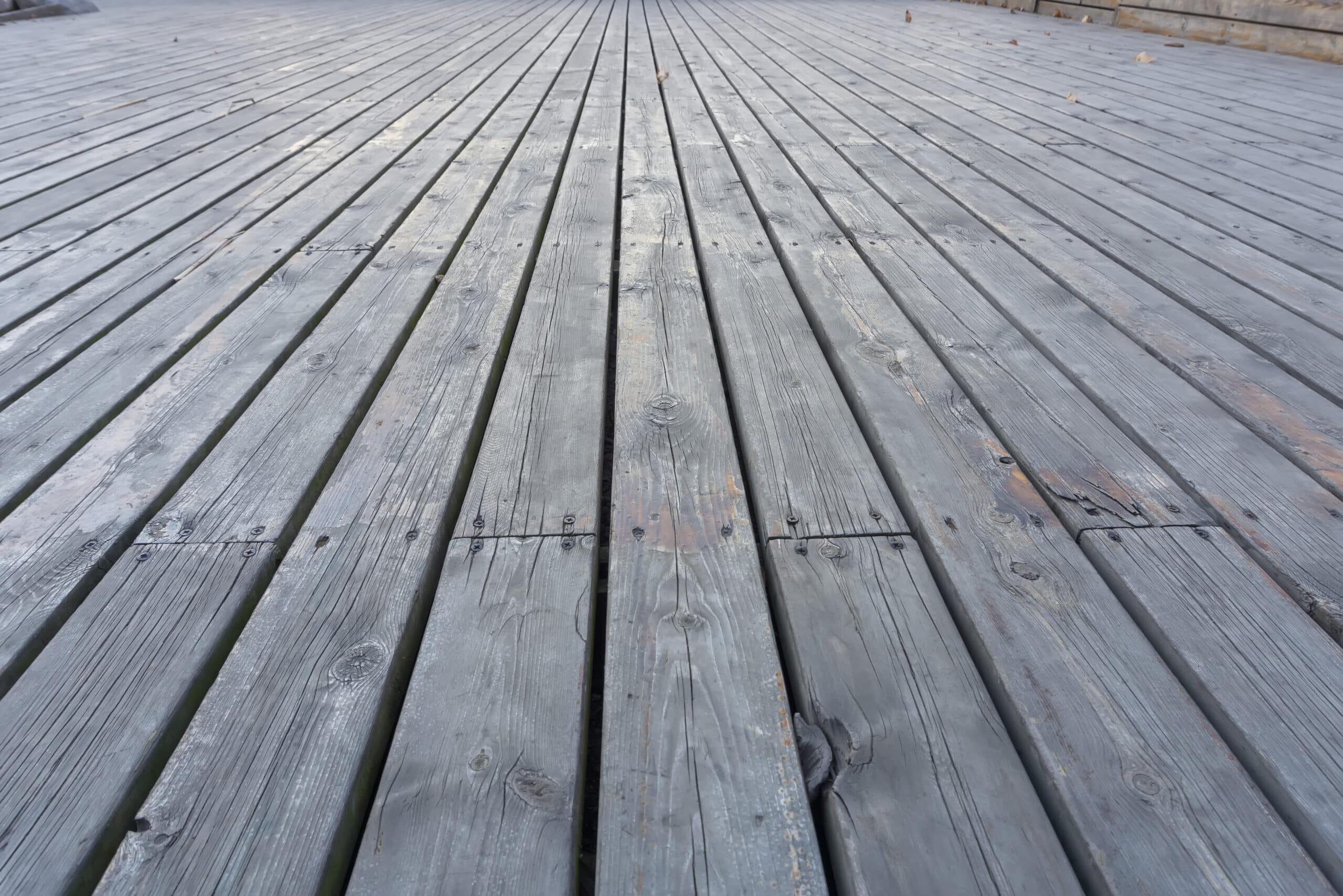 Close-up of gray, weathered wooden planks showing signs of aging and surface wear.