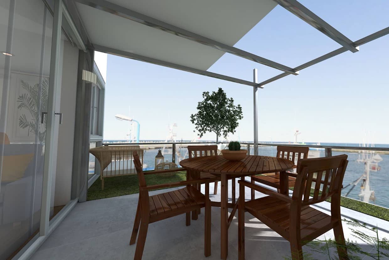 A sleek metal pergola-style awning with a white retractable shade covers a balcony dining area overlooking the ocean.