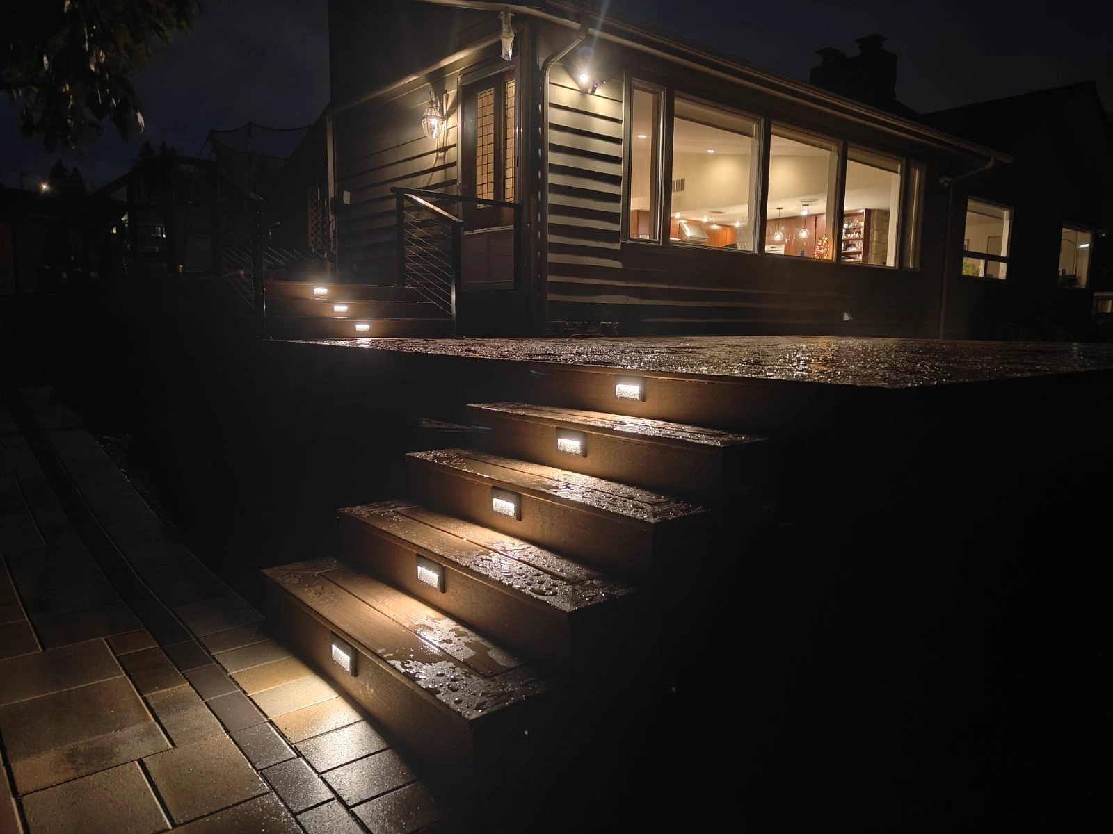 Deck stairs lit up at night, highlighting the best deck materials and craftsmanship.