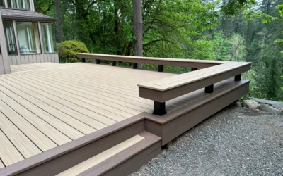 A contemporary deck with sleek railings and composite wood decking, surrounded by lush greenery, showcasing decking designs and ideas for outdoor spaces.