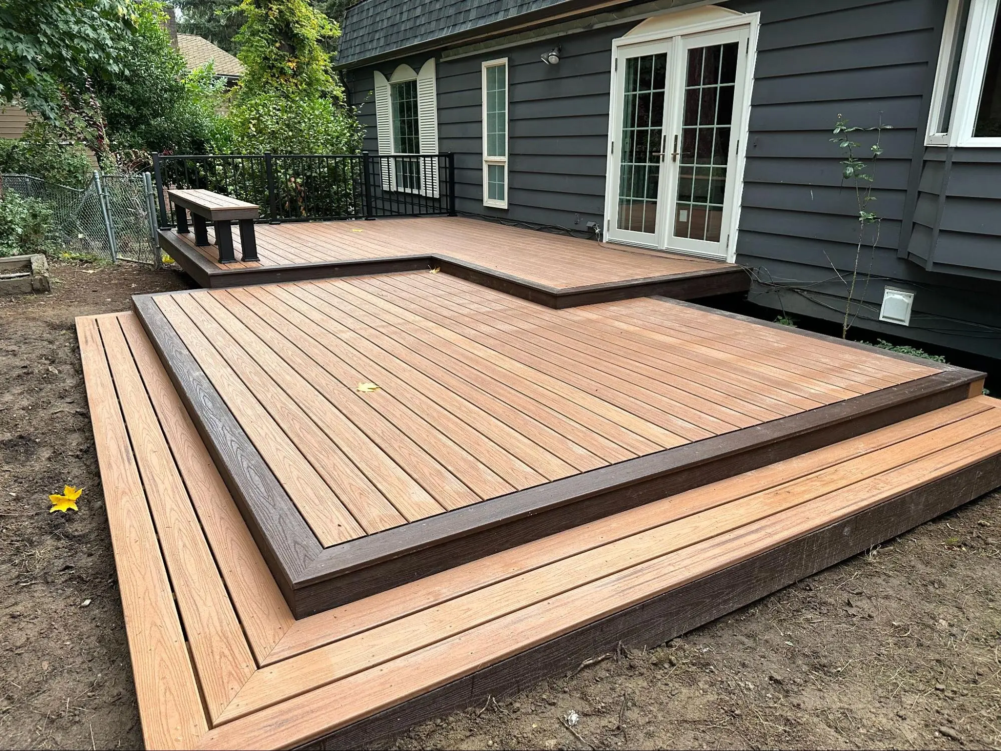 A newly installed deck with light wood decking and modern black railings, enhancing the outdoor living space.
