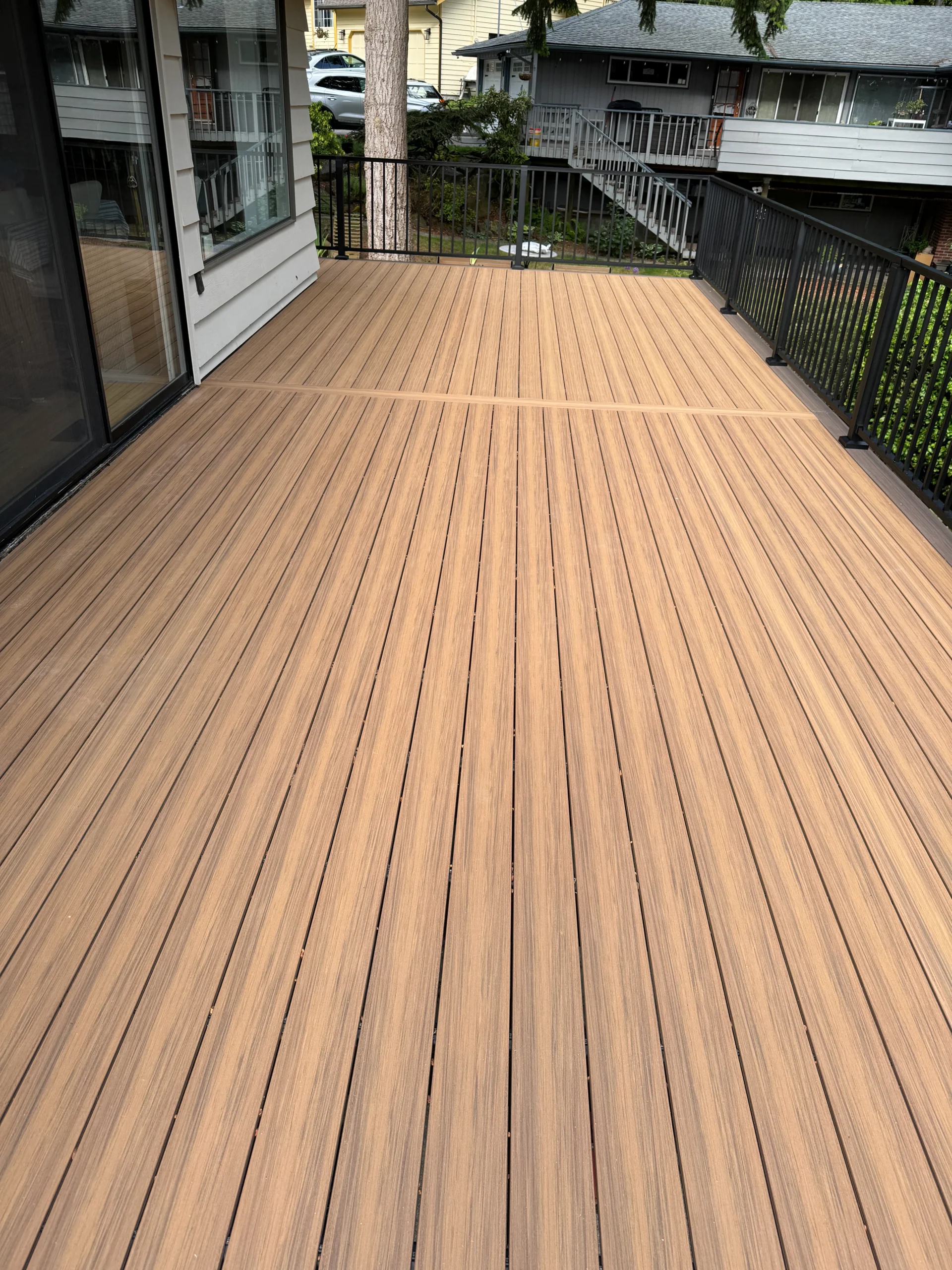 A beautifully restored deck with composite boards and black railing. Perfect for outdoor gatherings. Restore decks.