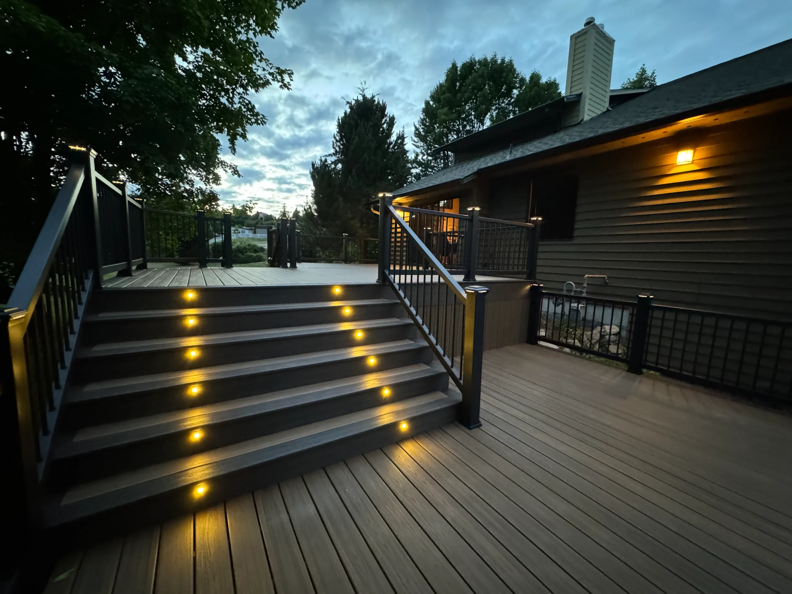A beautifully restored deck featuring LED lighting on the stairs and sleek black railing. Perfect for evening relaxation. Restore decks.