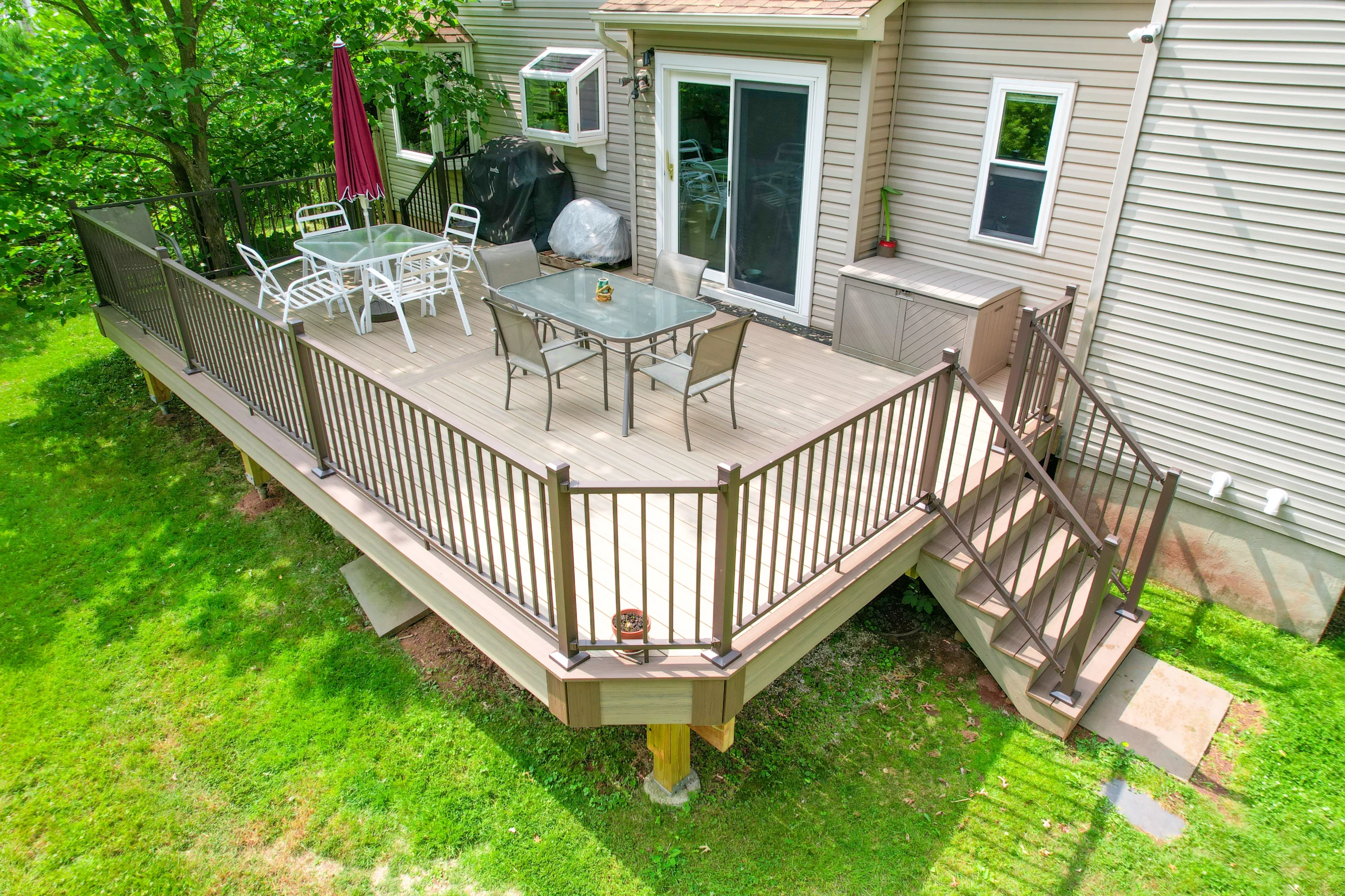 A large deck with a railing and dining set, highlighting the best deck materials for a functional and stylish outdoor space.