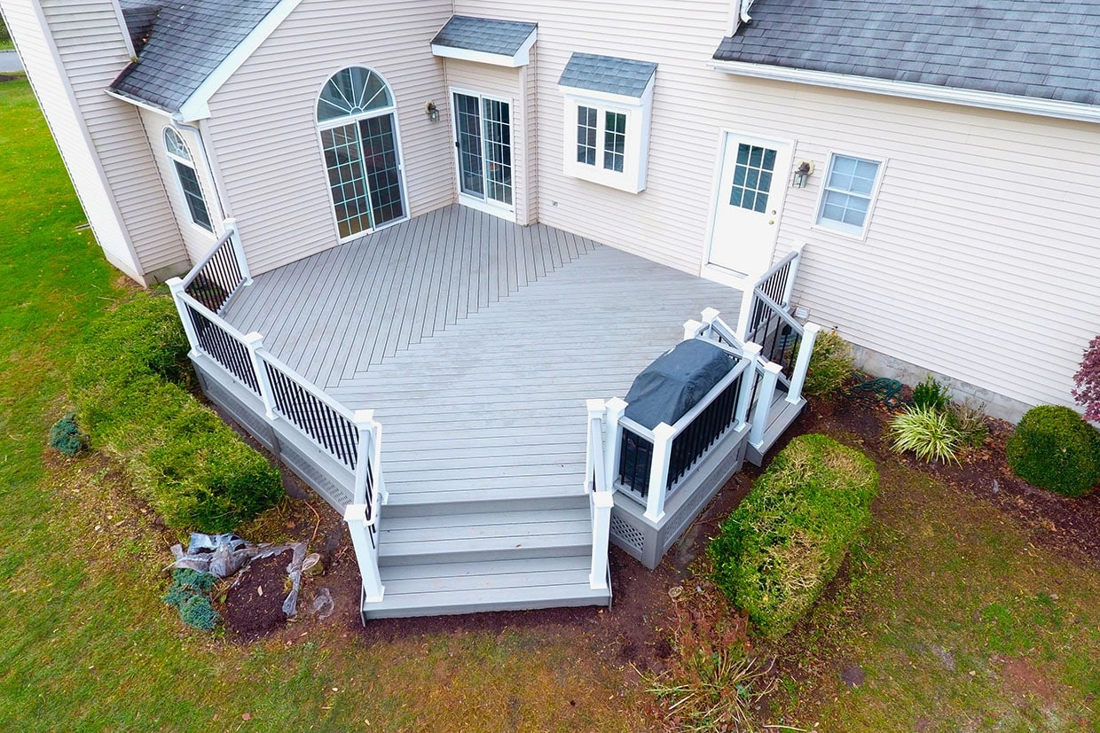 A spacious composite deck with white and black railing, perfect for small backyards, showcasing Trex vs Cedar Decking options.
