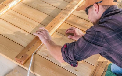 A carpenter aligning and adjusting decking boards for a precise fit in a Trex vs Cedar Decking project.