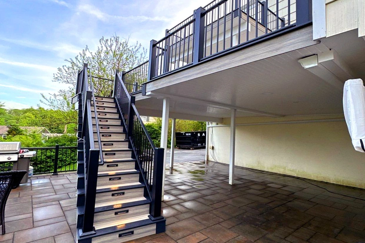 A stylish staircase with sleek black railings and LED lighting, showcasing deck installation trends