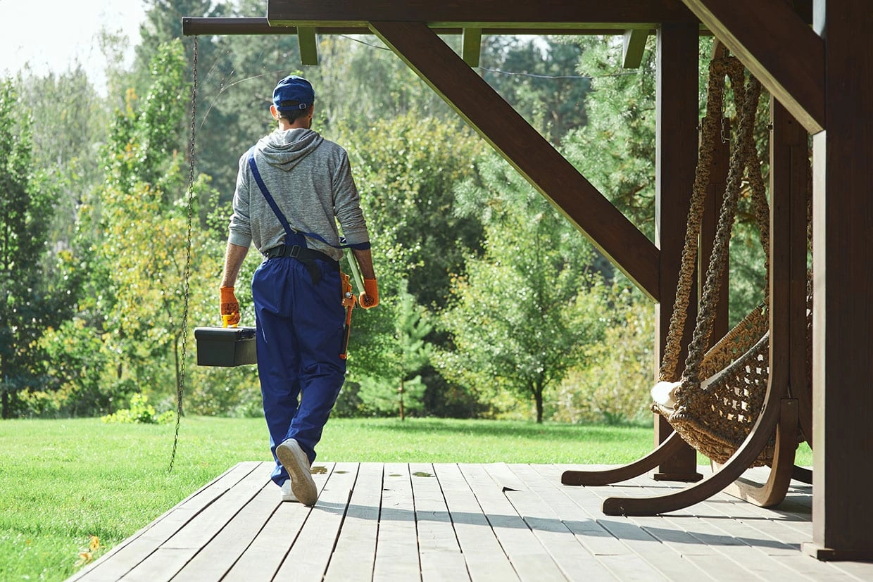 A skilled deck builder walking toward a beautiful deck, showcasing the expertise of Best Deck Builders Near You.