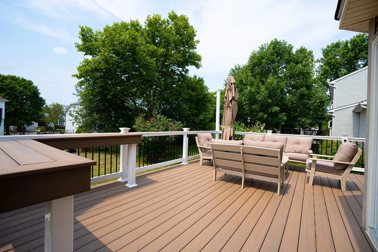 A freestanding deck with a seating area and railing, demonstrating the importance of anchoring a freestanding deck for long-term durability.