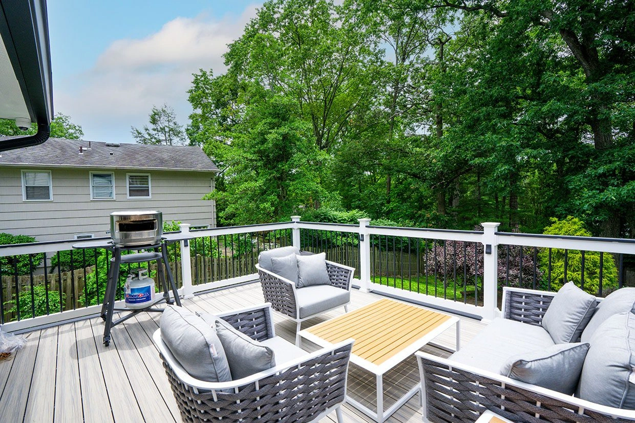 A freestanding deck with a seating area and grill, showcasing how to anchor a freestanding deck to ensure stability and enjoyment.
