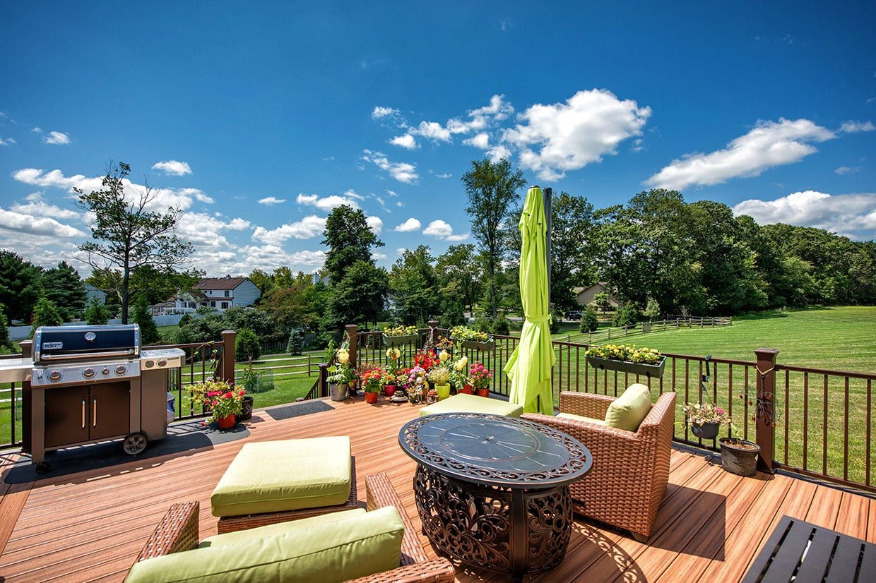 A freestanding deck with comfortable seating and a grill, showcasing how to anchor a freestanding deck for stability in outdoor spaces.