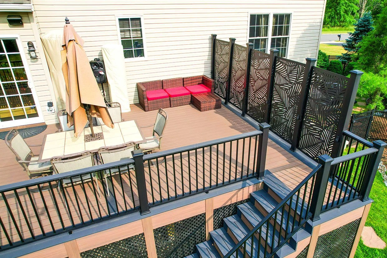 deck layouts A deck layout featuring a dining set, a seating area with red cushions, and stylish privacy screens.