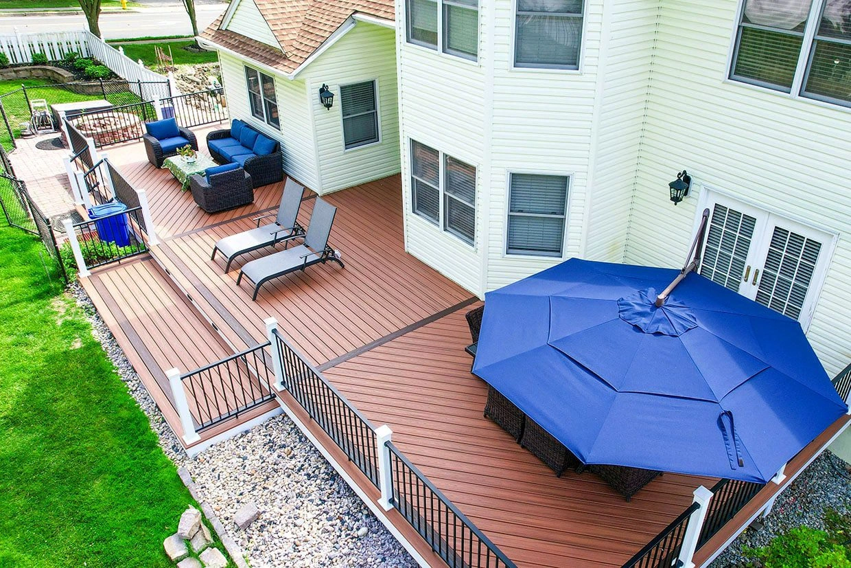 deck layouts A deck layout featuring lounge chairs, a shaded seating area with a large umbrella, and a stylish railing.