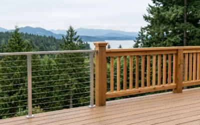 A wooden balcony overlooking the forest features a modern cable deck railing and traditional wood balusters.