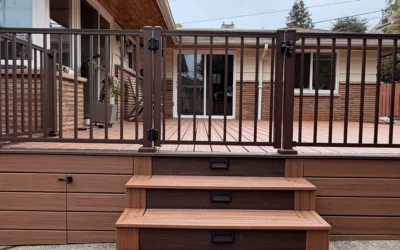 A vertical view of a composite deck installation in Issaquah WA with safety gates and lighted steps on a concrete patio.