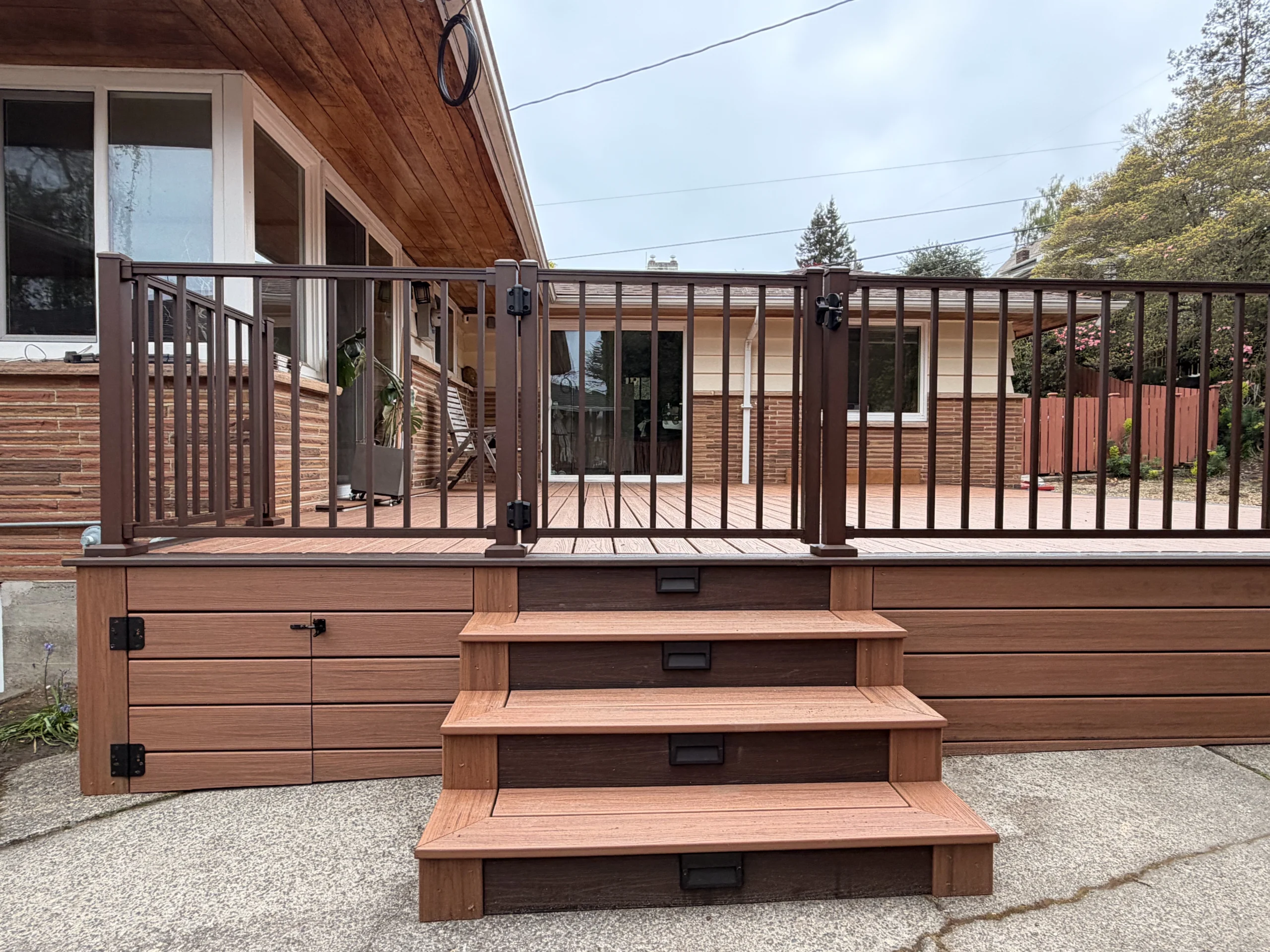 Custom Storage Solutions for Deck Installation in Issaquah WA A composite deck installation in Issaquah WA with a built-in storage compartment and integrated stair lighting.