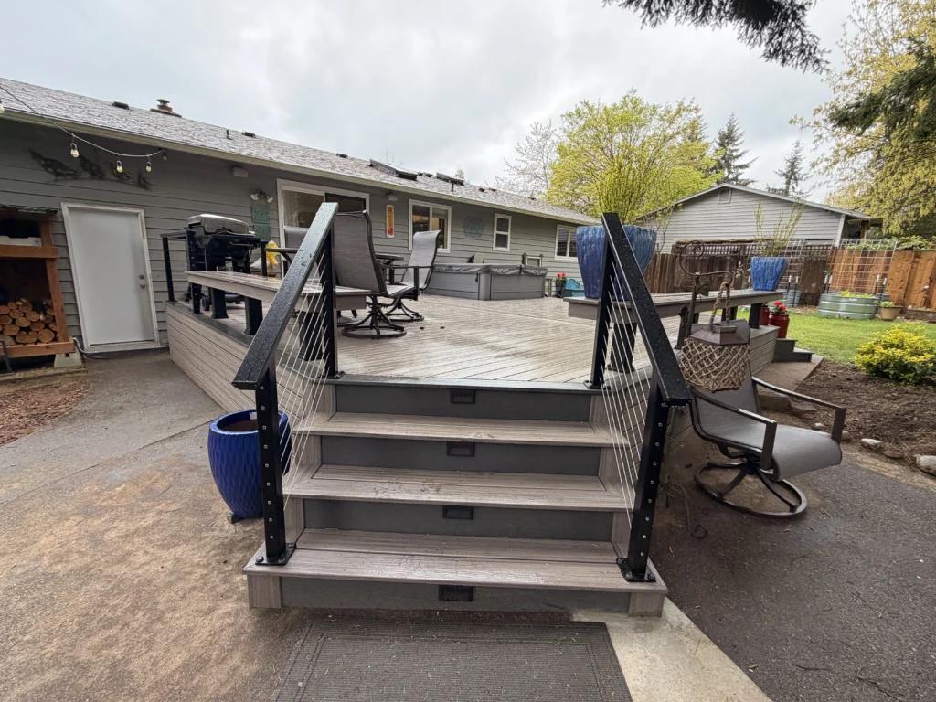 Olympic Decks Front view of grey steps with black cable railings leading up to a finished Composite Deck Installation in Seattle WA.