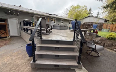 Front view of grey steps with black cable railings leading up to a finished Composite Deck Installation in Seattle WA.