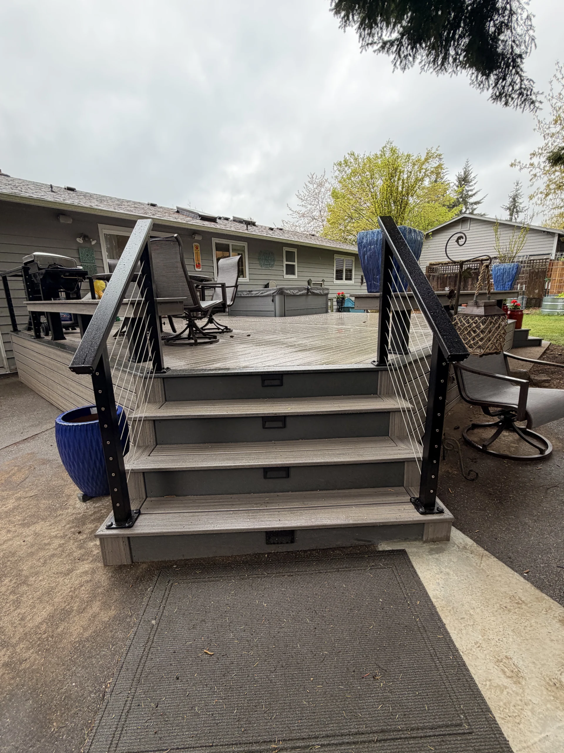 Modern stairs featuring a sleek Composite Deck Installation in Seattle WA with black cable railings.