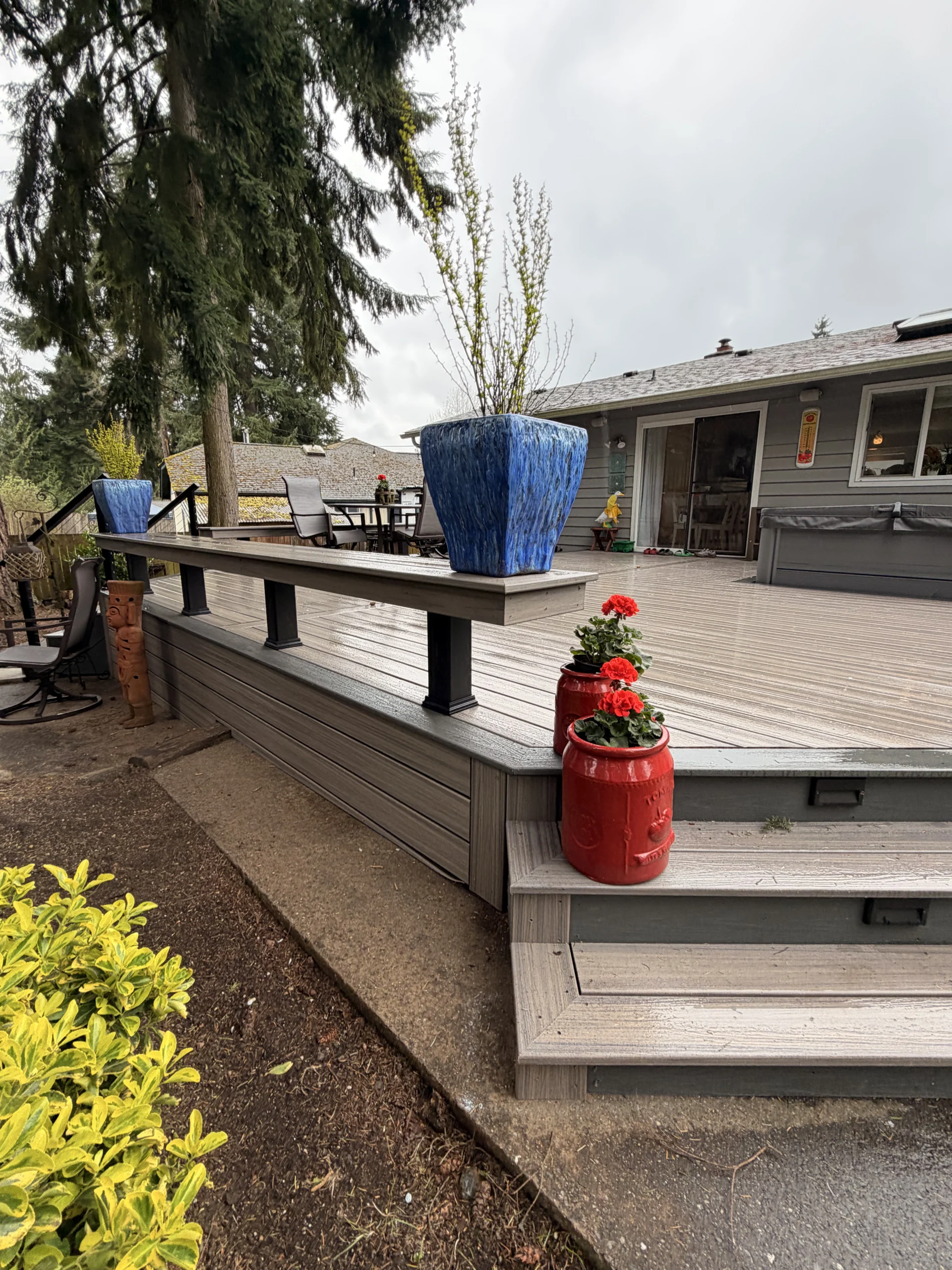 Vibrant red and blue planters decorating a beautiful Composite Deck Installation in Seattle WA.