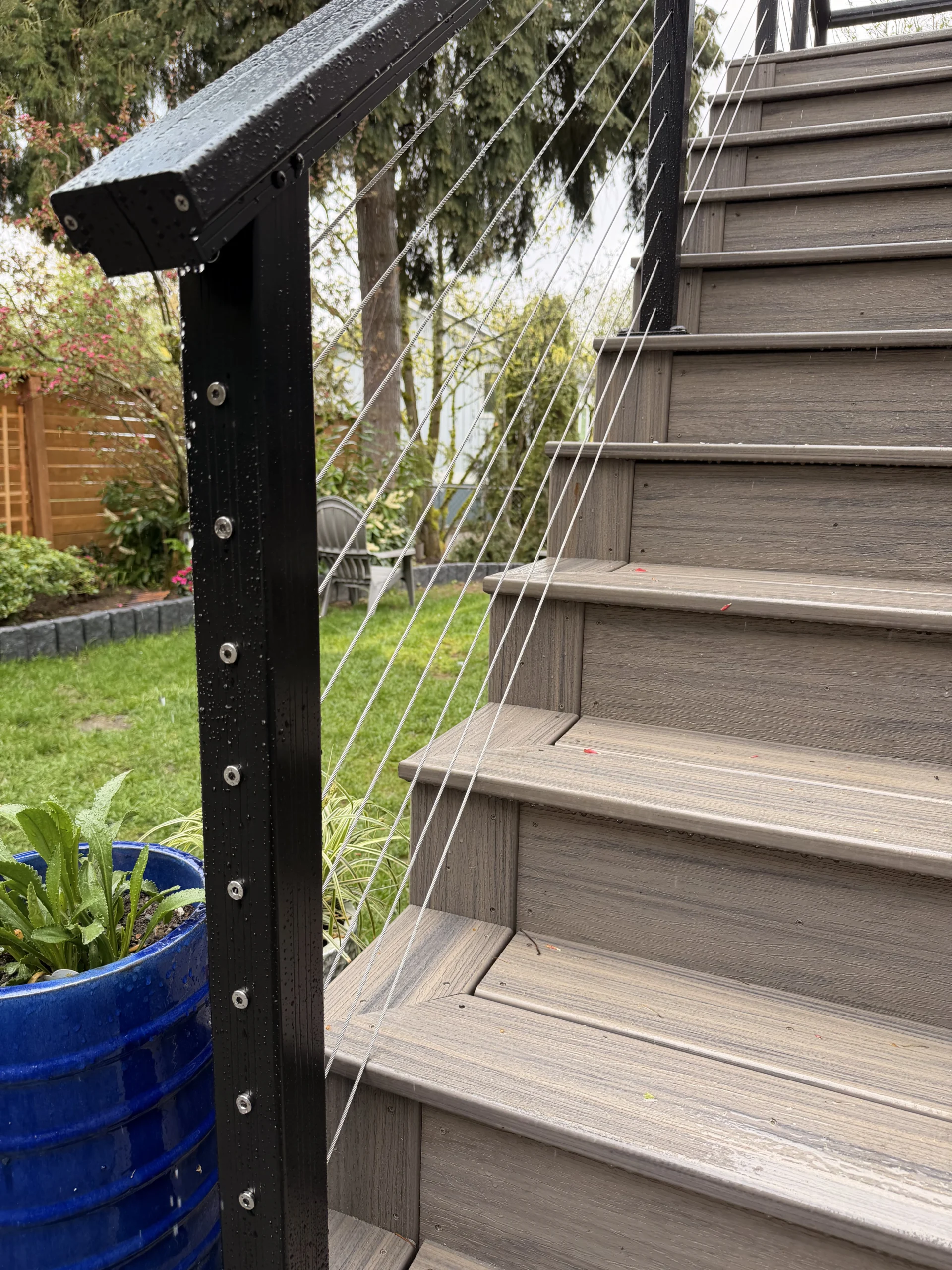 Stainless steel cable railing on wooden stairs during a second story deck installation seattle wa.