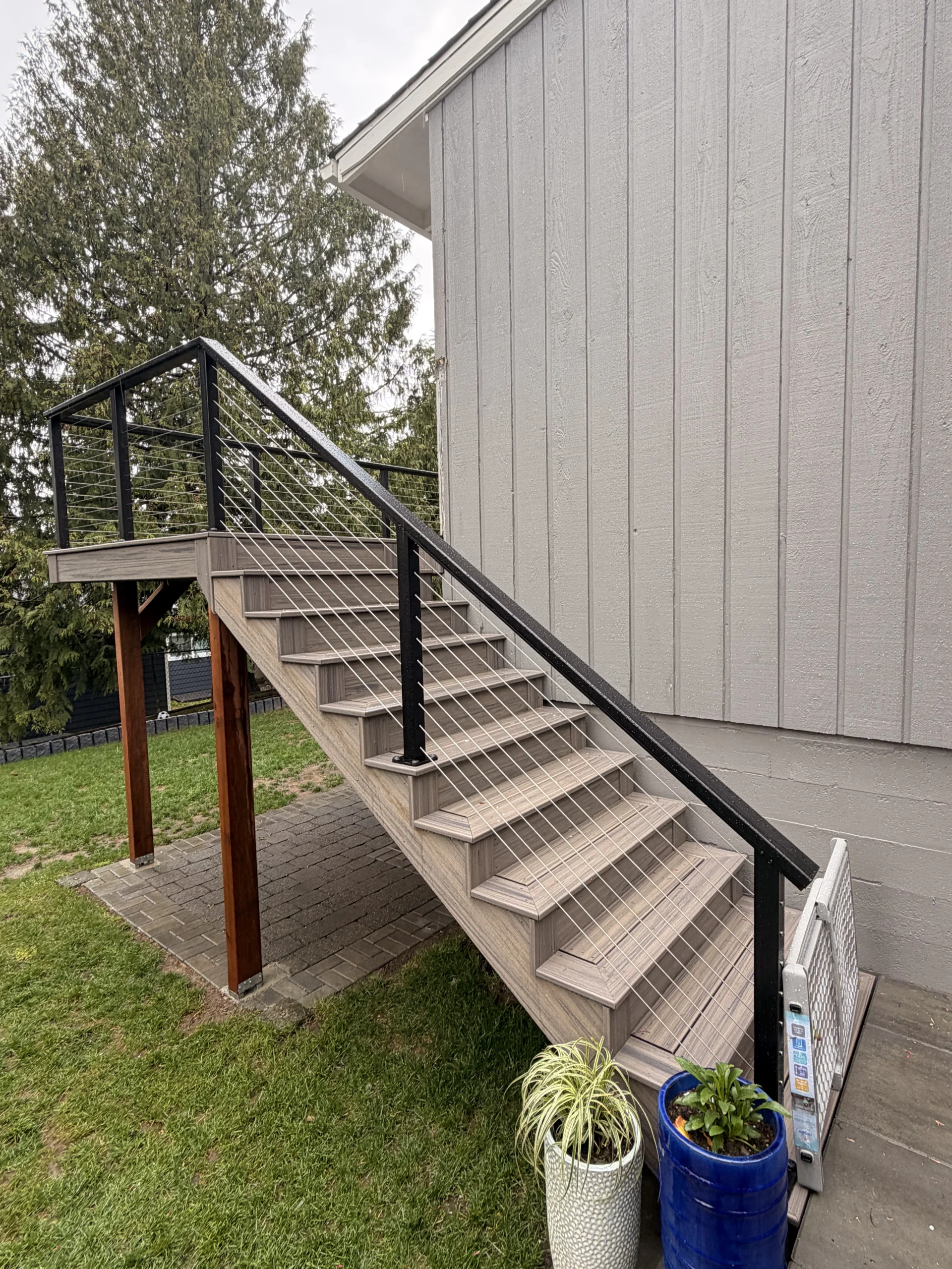 Olympic Decks Trex Transcend second-story deck stairs with black cable railing at a Seattle home.