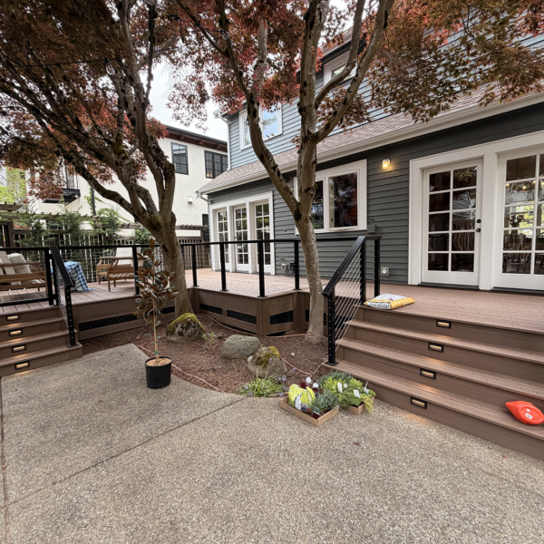 Multi-Level Composite Deck Featuring Black Cable Railings, Built-In Stair Lights, And A Mature Japanese Maple Tree.