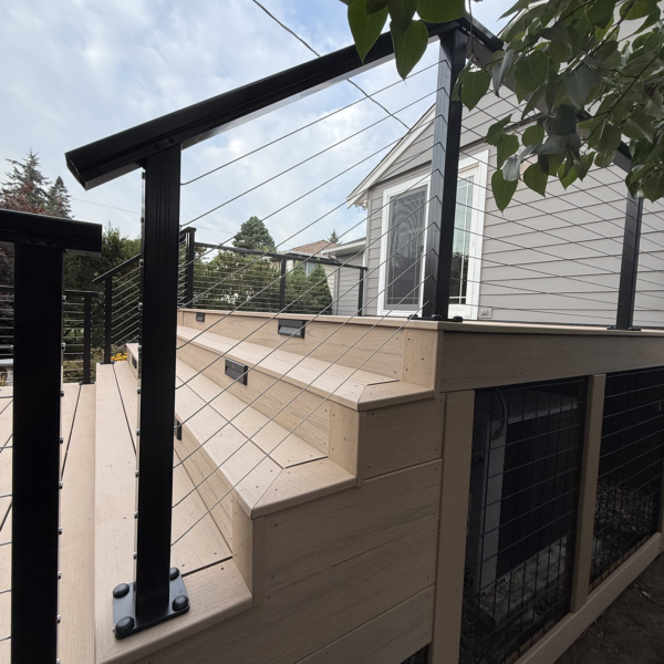 Second-story Trex deck replacement Upward Angle Of Composite Deck Steps With Built-In Lighting And Black Cable Handrails Leading To A Back Door.