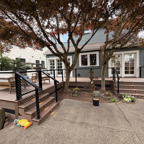 Wide Shot Of A Multi-Level Composite Deck Built Around Two Trees In A Residential Backyard.