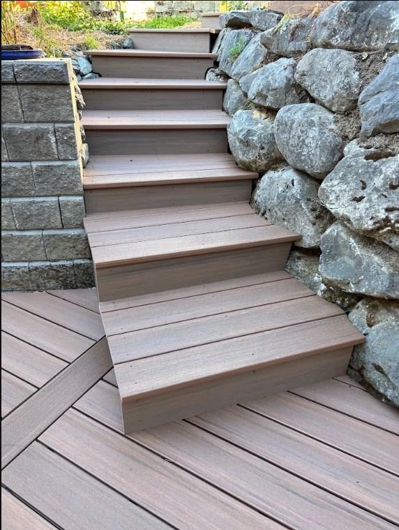 View Looking Up New Durable Composite Steps Built Between A Stacked Block Wall And A Boulder Retaining Wall, Replacing Old Wood.