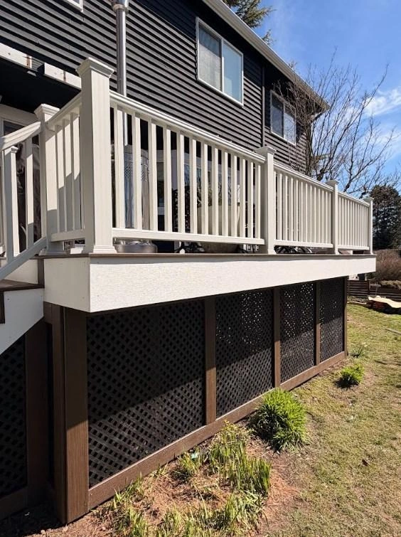 White railing and dark lattice skirting featured in a completed Trex Transcend deck replacement.
