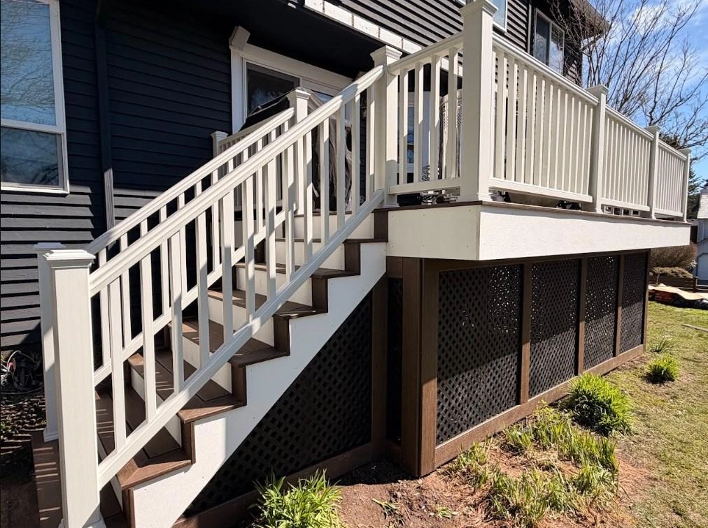 Elevated composite deck with white railings and lattice built during a Trex Transcend deck replacement.