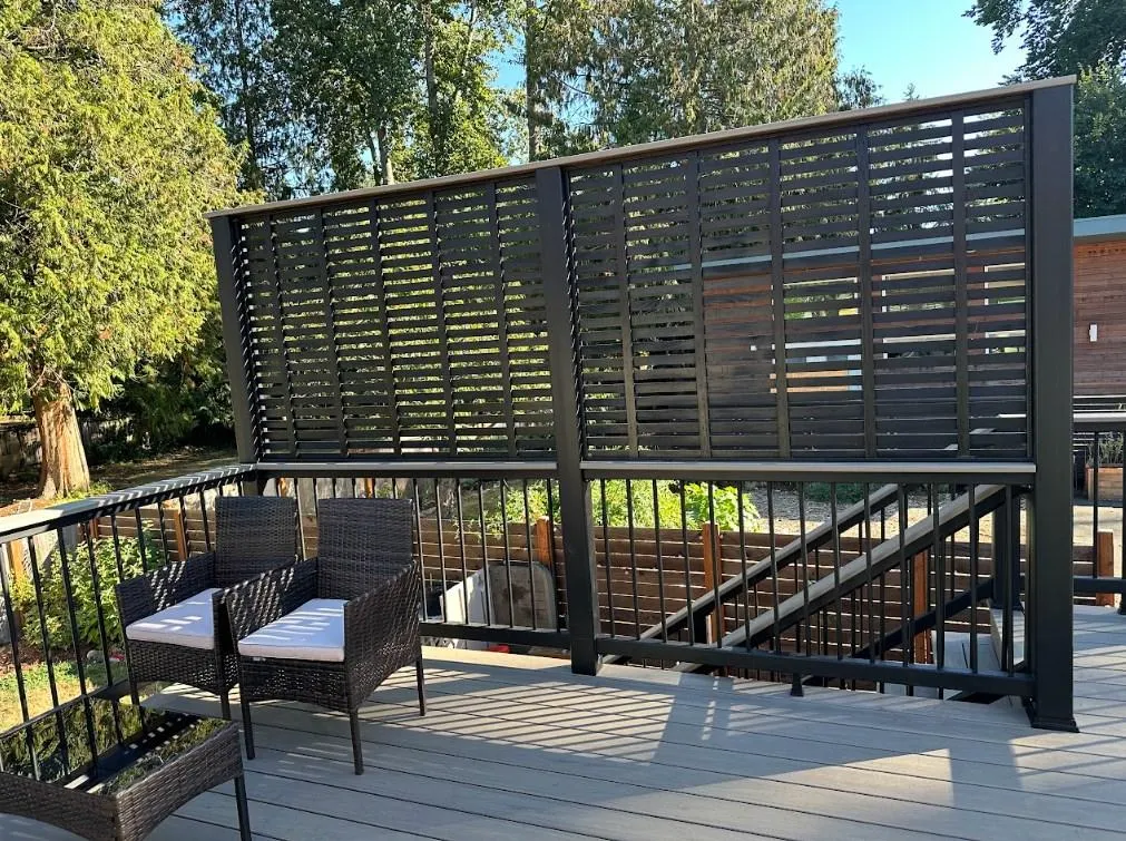 Modern privacy screen featured in an AZEK Vintage deck replacement in Bellevue. Black Privacy Fence And Wicker Chairs On An Azek Vintage Deck Replacement In Bellevue.