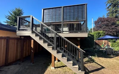 View From Below Of An Elevated Azek Vintage Deck Replacement In Bellevue, Featuring Black Railings And A Privacy Screen.