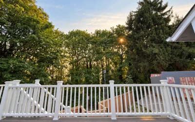 White Composite Deck Railing Overlooking A Wooden Yard Boundary While Evaluating Cedar Vs Pressure Treated Fence.