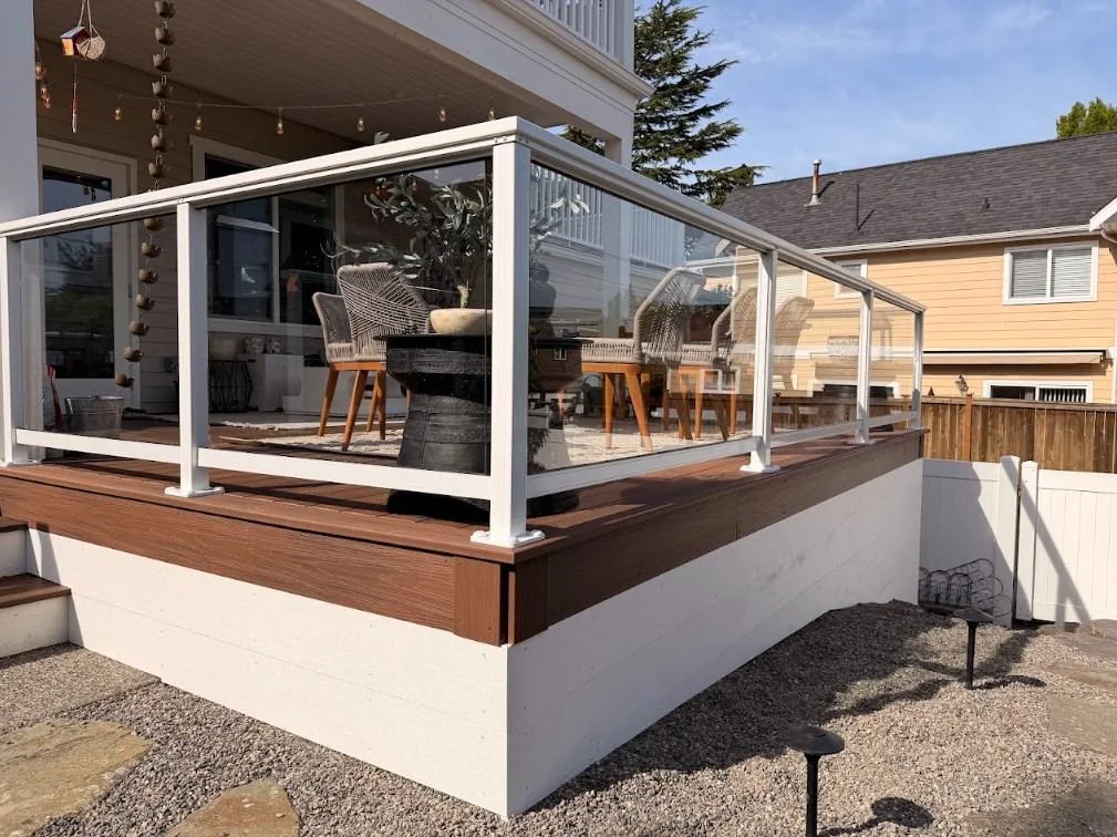 Clear Glass Panel Railing Installed Around A Ground-Level Azek Deck Replacement In Edmonds.