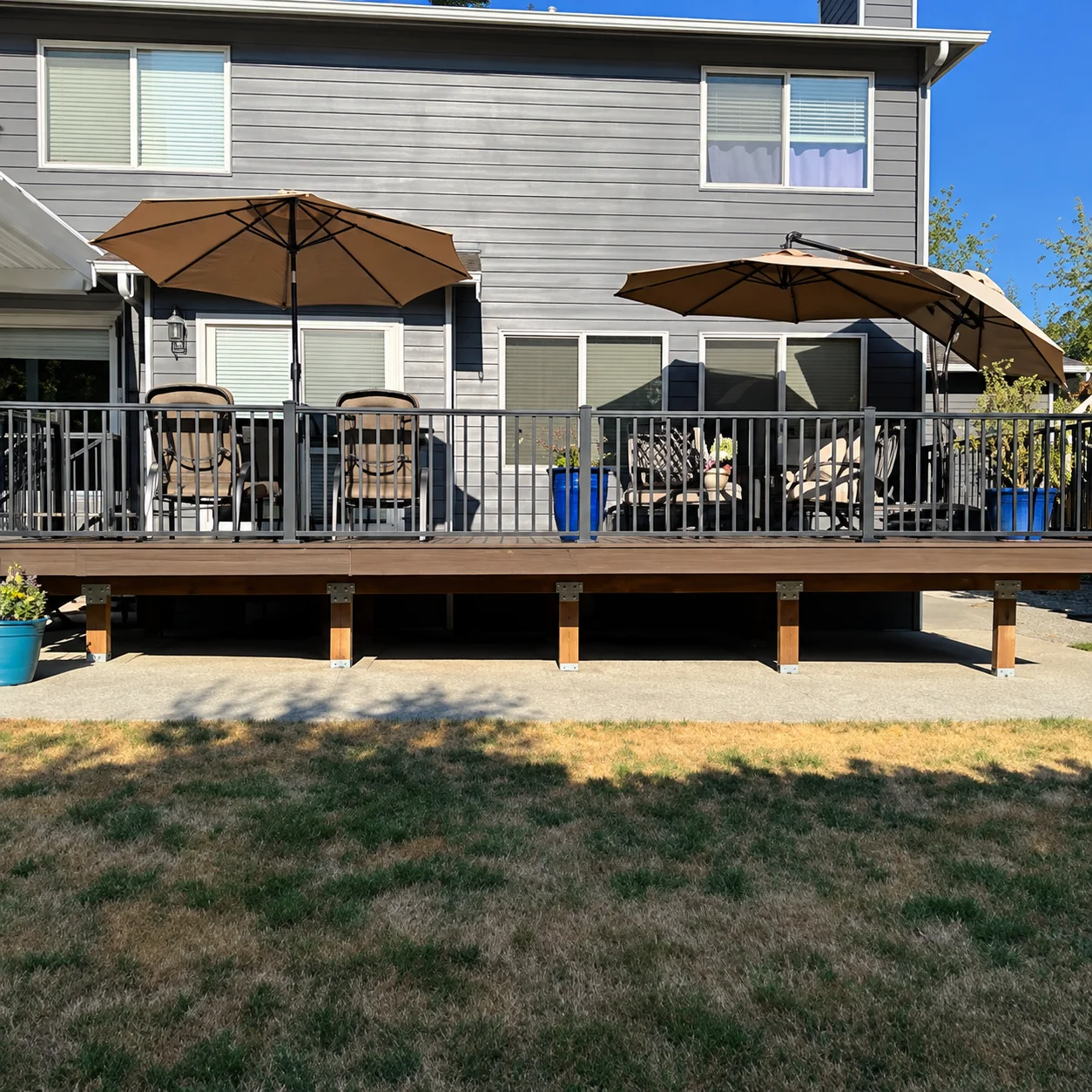 Elevated backyard composite patio area highlighting a Trex Transcend deck replacement in Bothell. Trex Composite Deck Replacement With Cable Railing And Outdoor Seating In Bothell, Wa