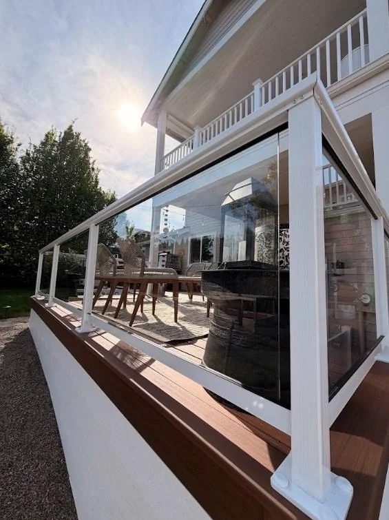 Clear Glass Railing System Gleaming In The Sun On A Ground-Level Azek Deck Replacement In Edmonds.